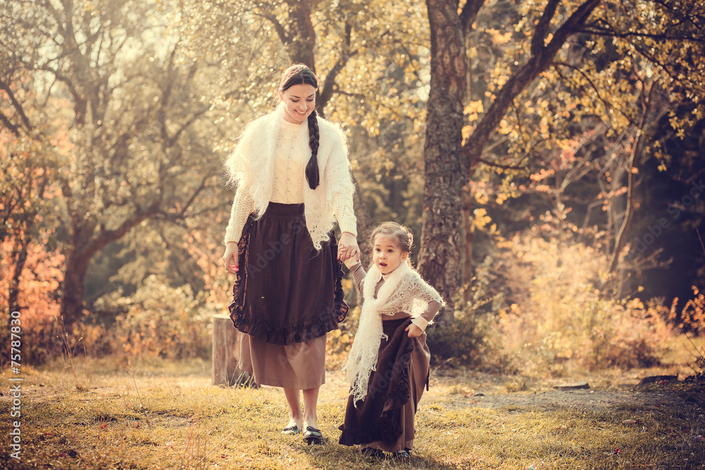 Fototapeta premium Mother and her daughter in vintage clothes in autumn