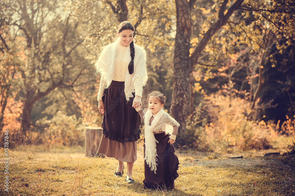 Fototapeta premium Mother and her daughter in vintage clothes in autumn