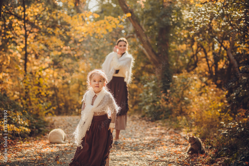 Fototapeta premium Mother and her daughter in vintage clothes in autumn