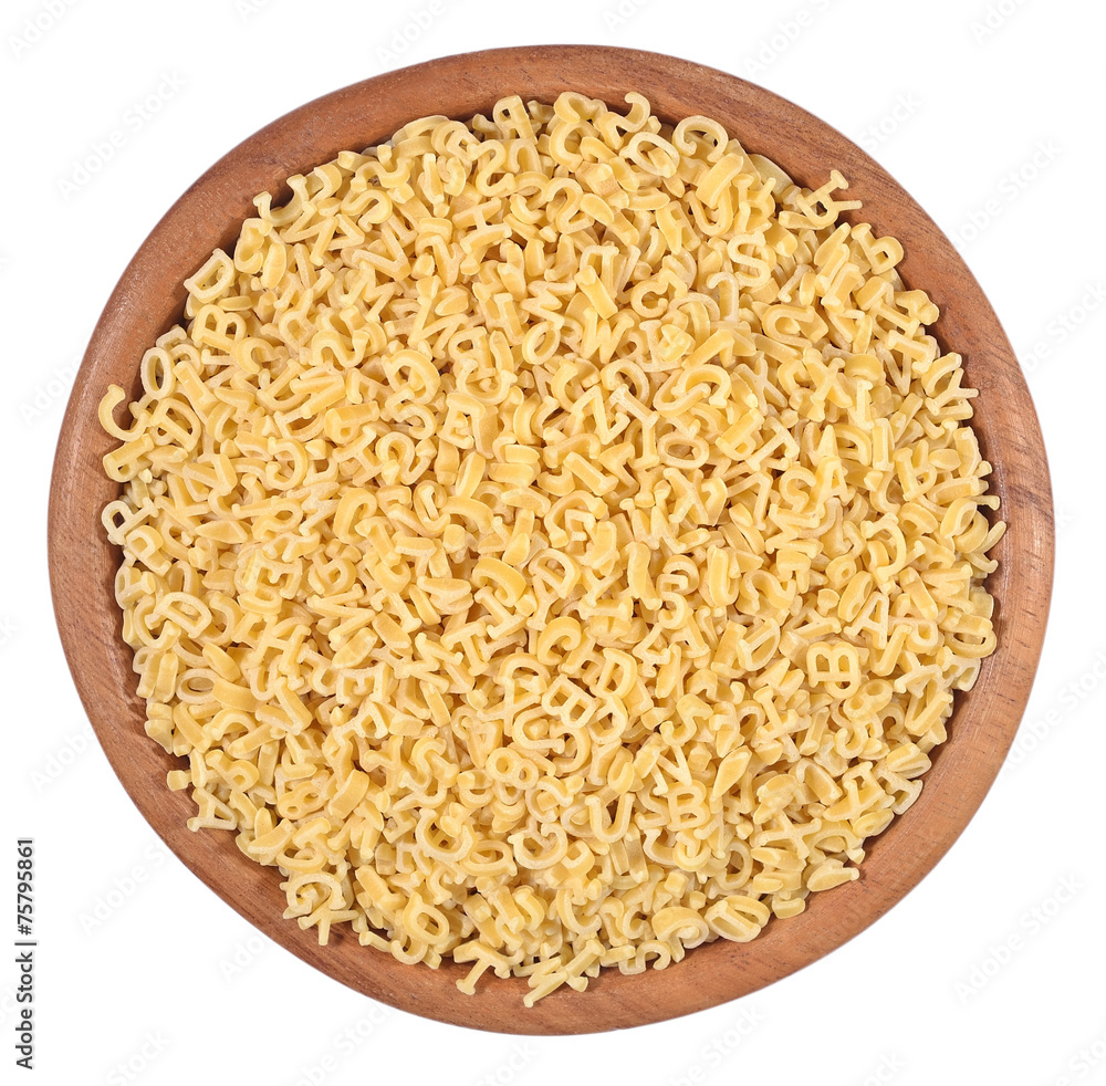 Alphabet pasta in a wooden bowl on a white