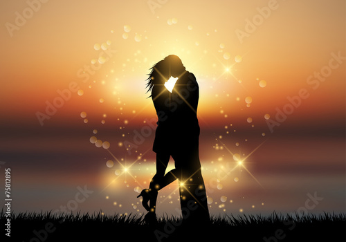 Couple kissing against a sunset background