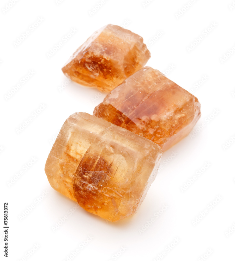 Brown caramelized lump cane sugar cube isolated on white backgro Brown caramelized lump cane sugar cube isolated on white backgro