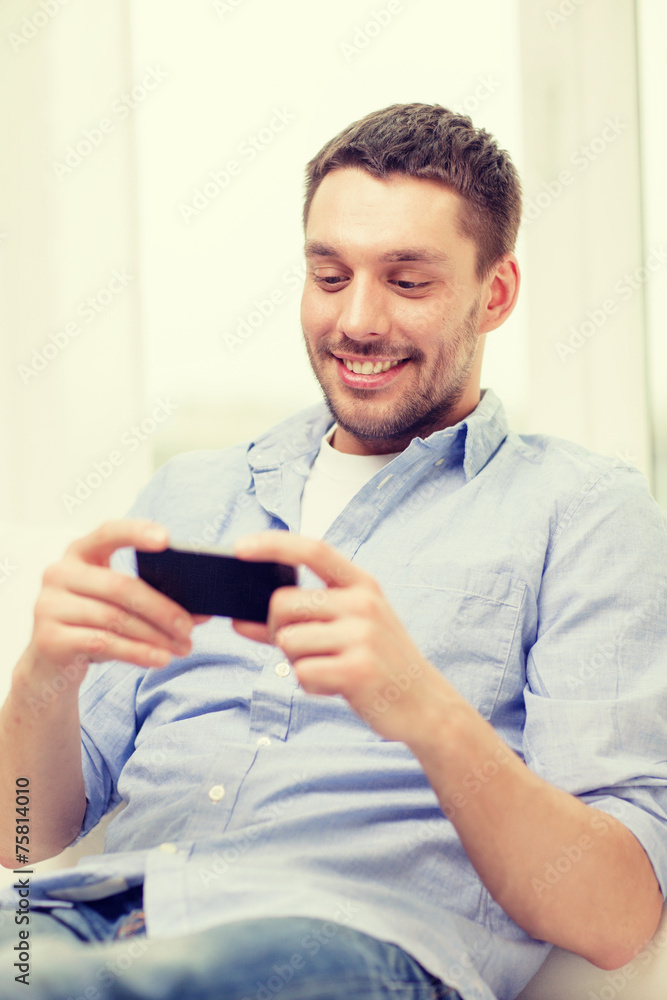 smiling man with smartphone at home smiling man with smartphone at home