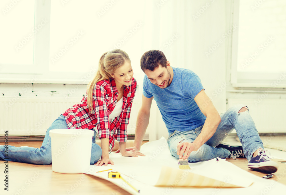 smiling couple smearing wallpaper with glue smiling couple smearing wallpaper with glue