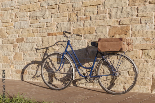 Vintage bicycle and old suitcase in a stone wall © irantzuarb