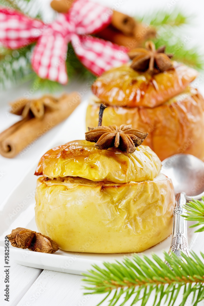 baked apples with honey, curds, raisins and nuts in a white plate decorated pine branches, cinnamon sticks and anise star on a wooden background baked apples with honey, curds, raisins and nuts in a white plate decorated pine branches, cinnamon sticks and anise star on a wooden background