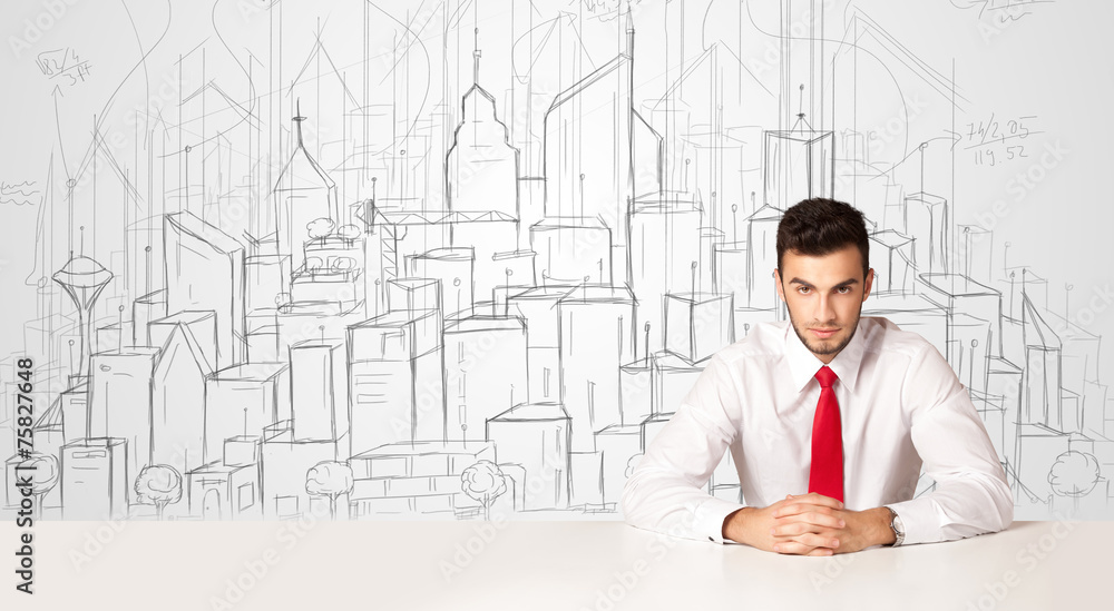Businessman sitting at the white table with hand drawn buildings Businessman sitting at the white table with hand drawn buildings
