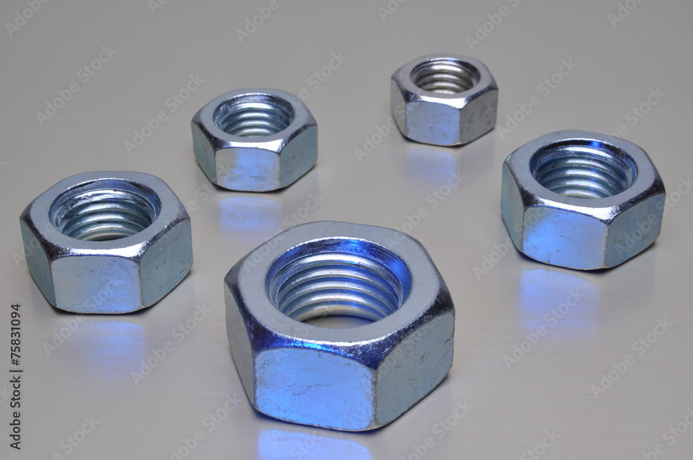 Group of steel nuts with blue light reflection Group of steel nuts with blue light reflection