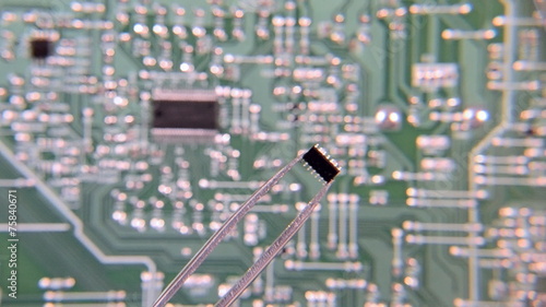 Chip tweezers through the lens to the circuit Board background photo