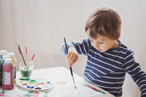 Fotografi Cute little boy painting in his album