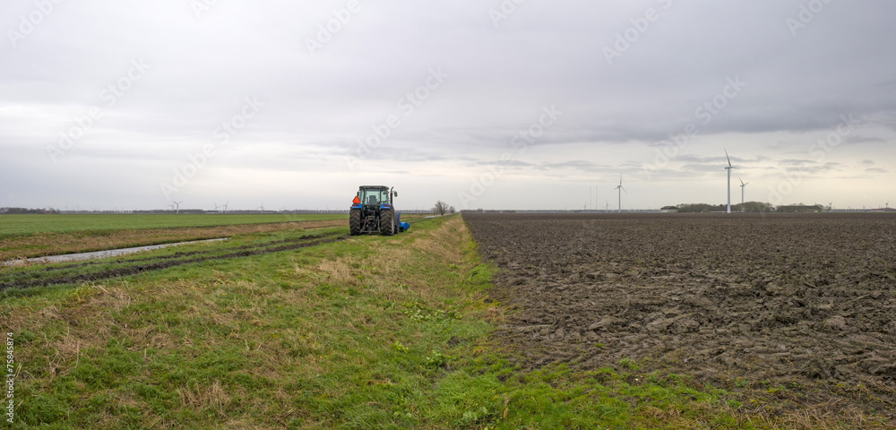 Obraz premium Tractor parked along a canal in winter
