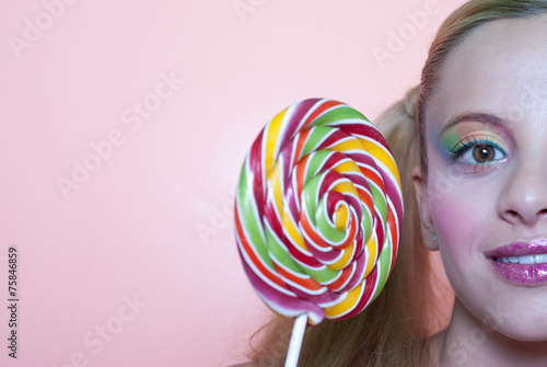 Girl holding a lolly pop, in pink background