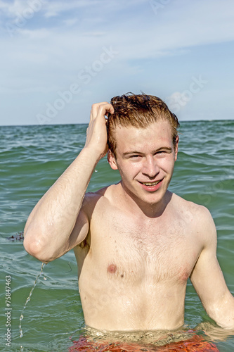 teenage boy enjoys swimming in the ocean © travelview