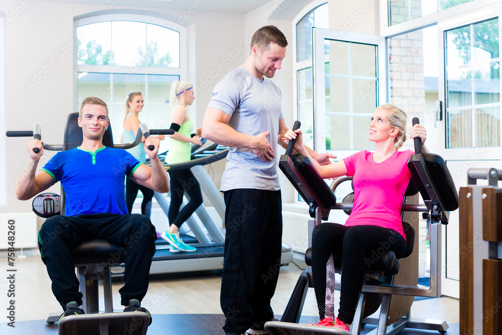 Frau im Fitness Studio mit personal trainer Frau im Fitness Studio mit personal trainer