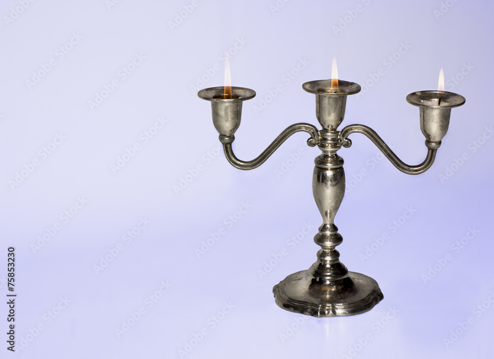 Silver candlestick holding three almost burnt-out candles Silver candlestick holding three almost burnt-out candles