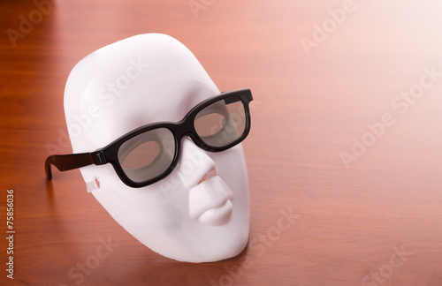 Theater mask in glasses on the table photo