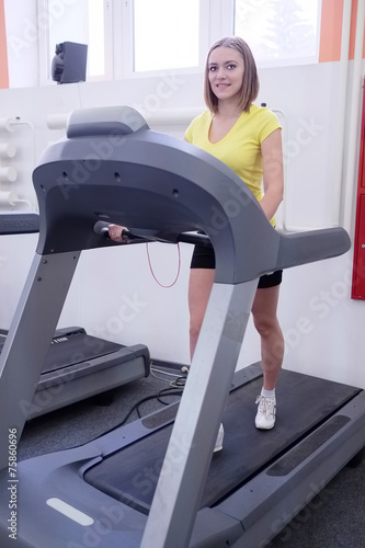 young woman doing exercises on treadmill