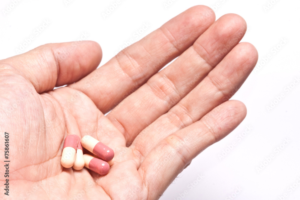Hand holding a pill capsule.