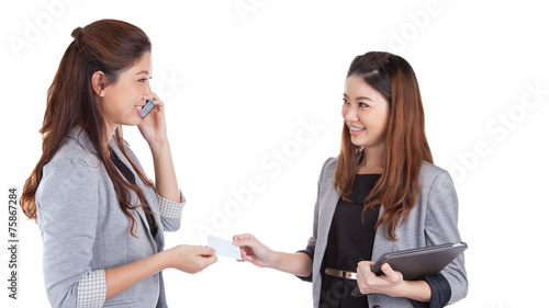 Two pretty businesswomen exchanging business cards