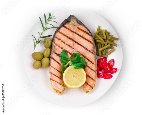 White plate of salmon steak with vegetables.