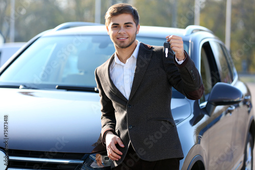 Businessman holding car key...