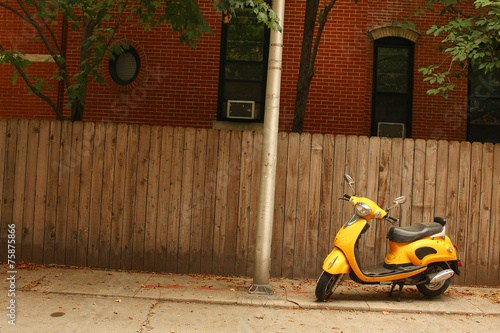 A court yard with a  yellow vespa