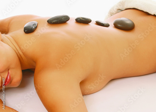 A woman getting a stone therapy in spa center  close-up 
