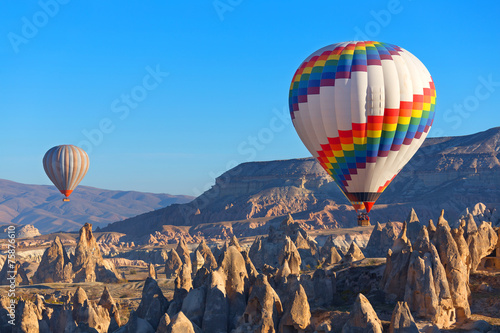 Balloons flying over rock landscape at Cappadocia Turkey.