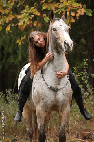 Beautiful girl riding a horse without bridle or saddle