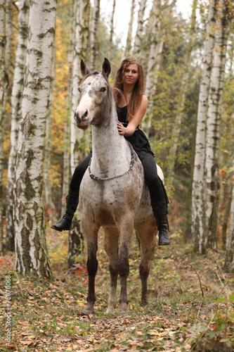 Young girl with appaloosa horse in autumn