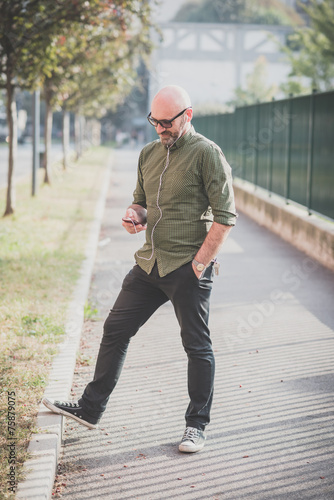 Mature man listening to music outdoors