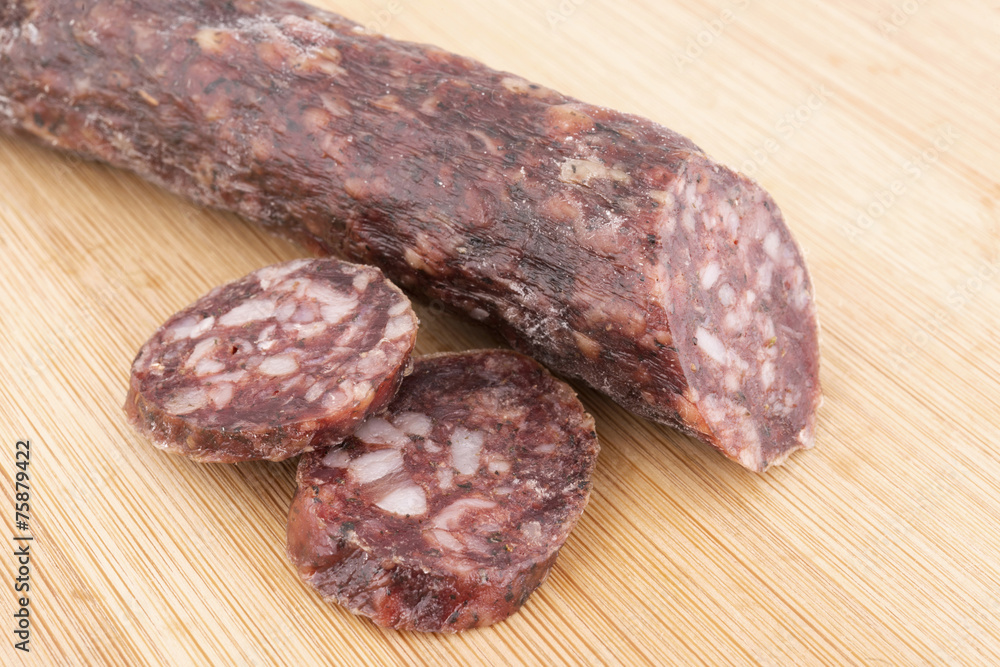 Dried sausage and slices on wooden board Dried sausage and slices on wooden board