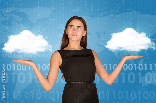 Canvas-taulu Businesswoman holding two white clouds, as if chosing