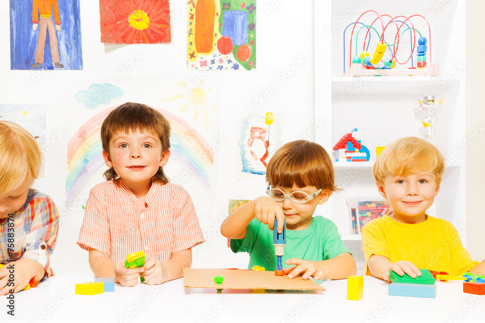 Fototapeta premium Group of boys in classroom with toy work tools