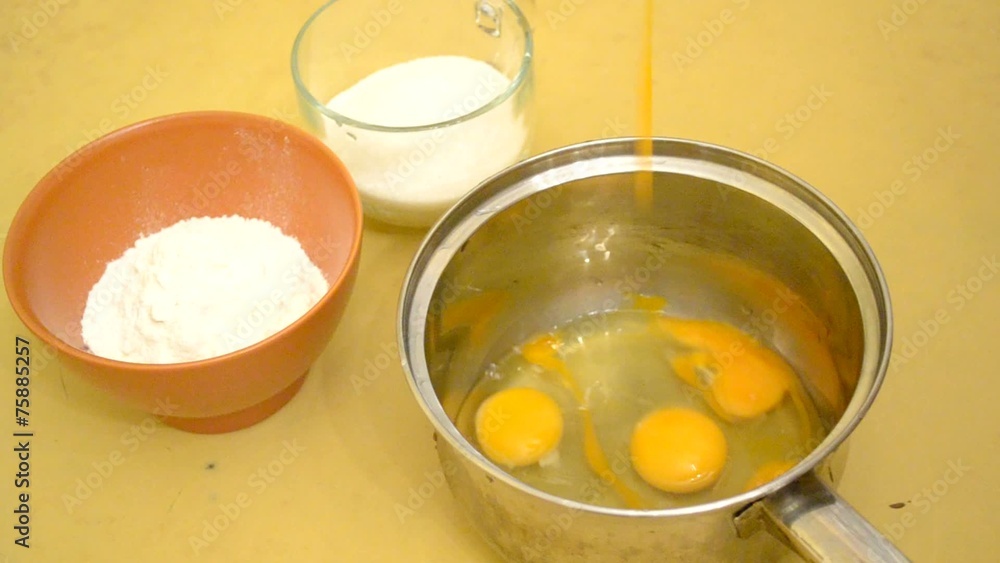 Preparing egg sponge - pouring eggs into saucepan and beating up Preparing egg sponge - pouring eggs into saucepan and beating up