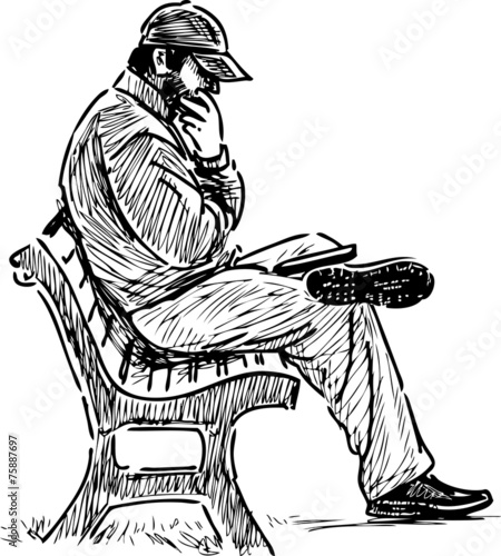 man reading on a park bench