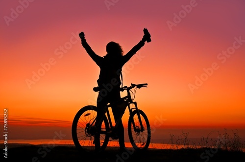 Biker-Girl at the sunset near lake