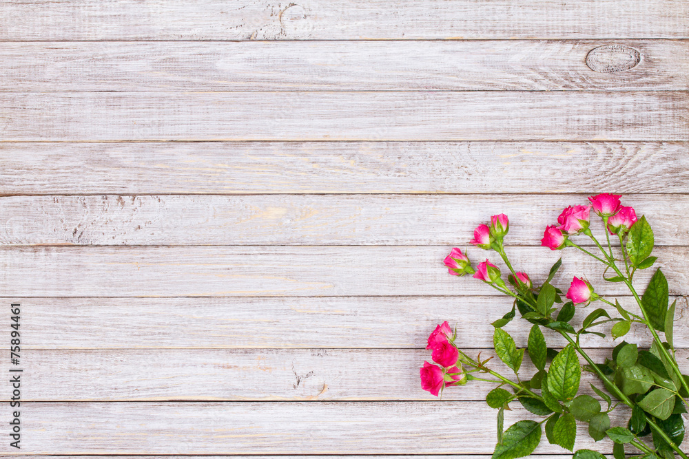 Fototapeta premium Red roses on wooden backround. Copy space