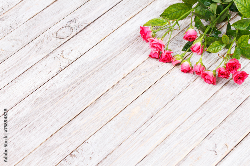 Obraz premium Red roses on wooden backround. Copy space