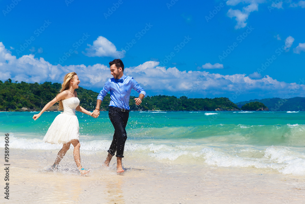 happy bride and groom having fun on a tropical beach