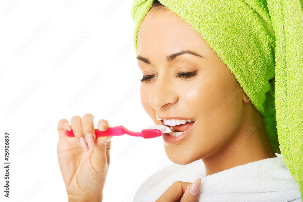 Portrait of a woman in bathrobe brushing teeth Portrait of a woman in bathrobe brushing teeth