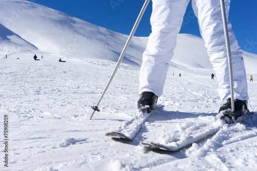 Close up of a skier’s feet with ski poles.