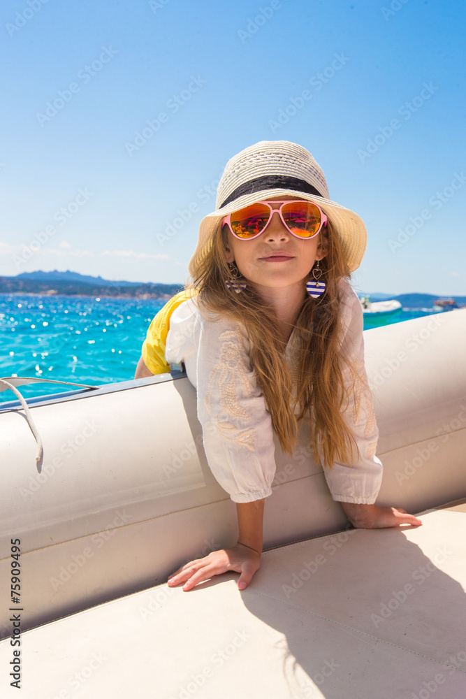 Cute little girl enjoying sailing on boat in the open sea Cute little girl enjoying sailing on boat in the open sea