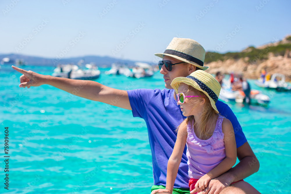 Young father with adorable girl resting on a big boat