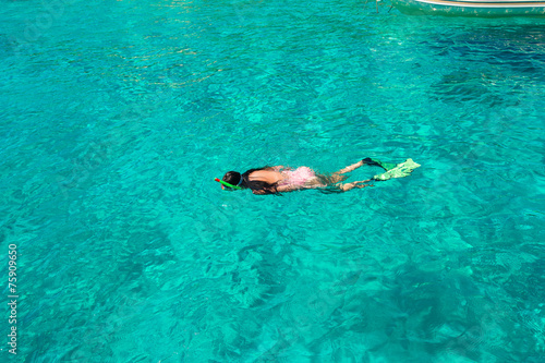 Beautiful girl snorkeling in clear tropical turquoise waters