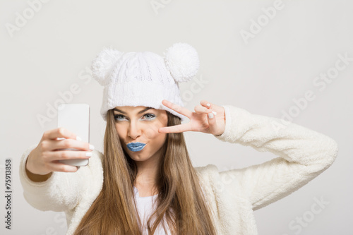 Photography Cute teenage girl with blue lips taking a selfie with smartphone