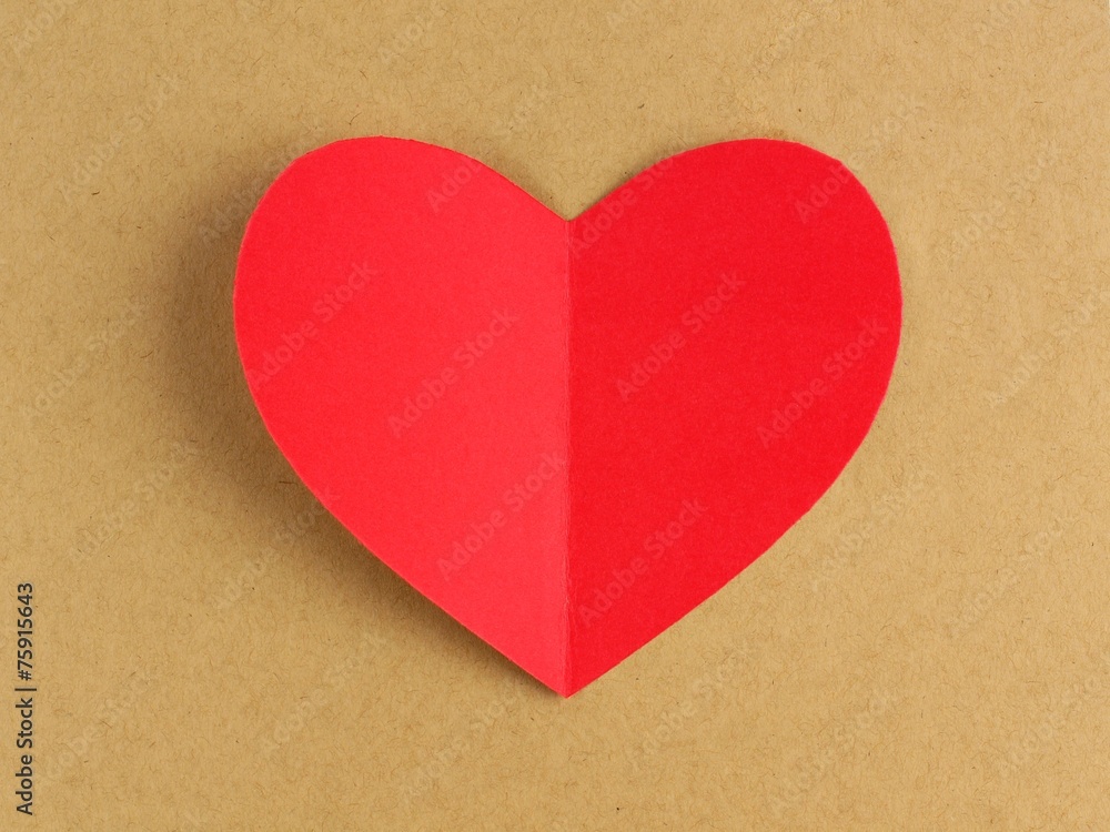 Red Valentines Day heart against a brown paper background Red Valentines Day heart against a brown paper background