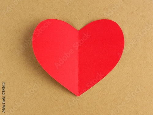 Red Valentines Day heart against a brown paper background