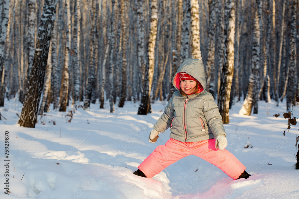 A little girl playing in a birch grove A little girl playing in a birch grove