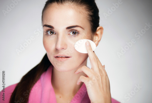 Fresh girl cleaning face with cotton swab